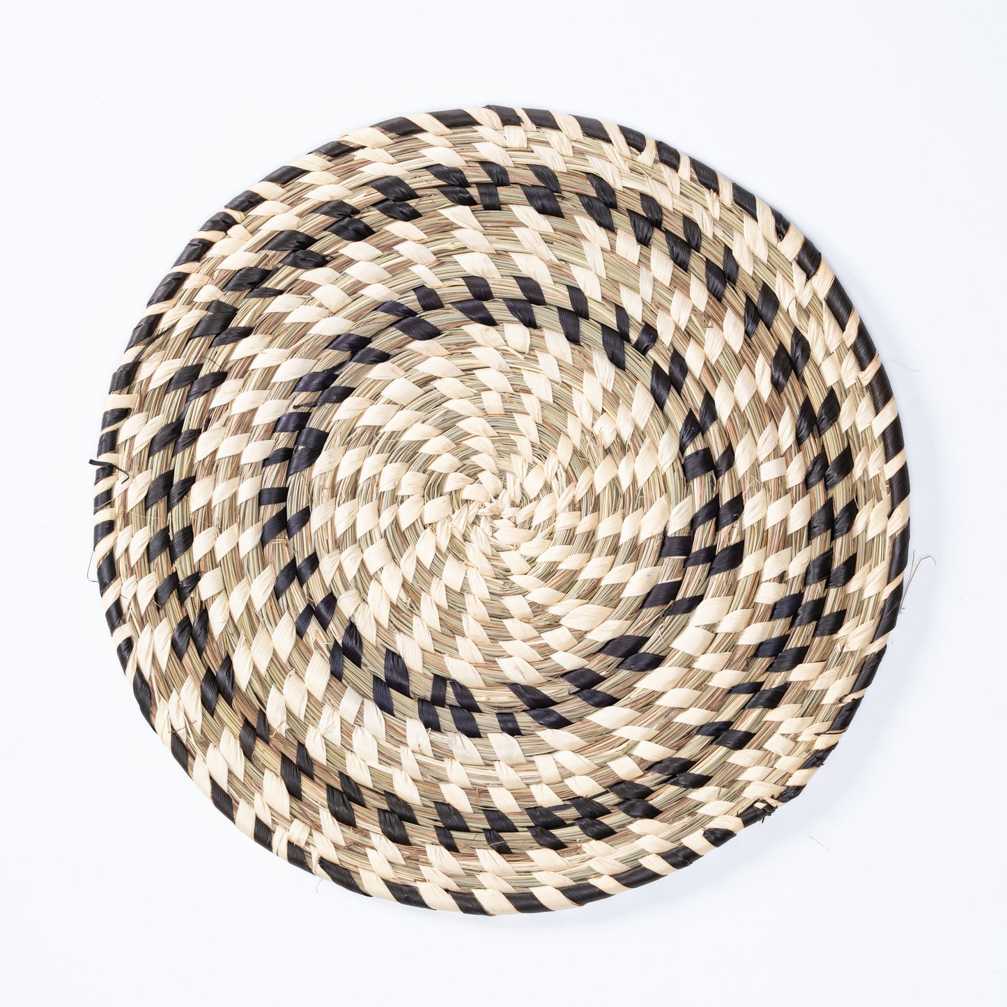 Black and white handwoven Sabai grass plate mat top view
