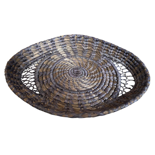 Indigo handwoven basket used to hold fresh oranges, styled on a kitchen table.