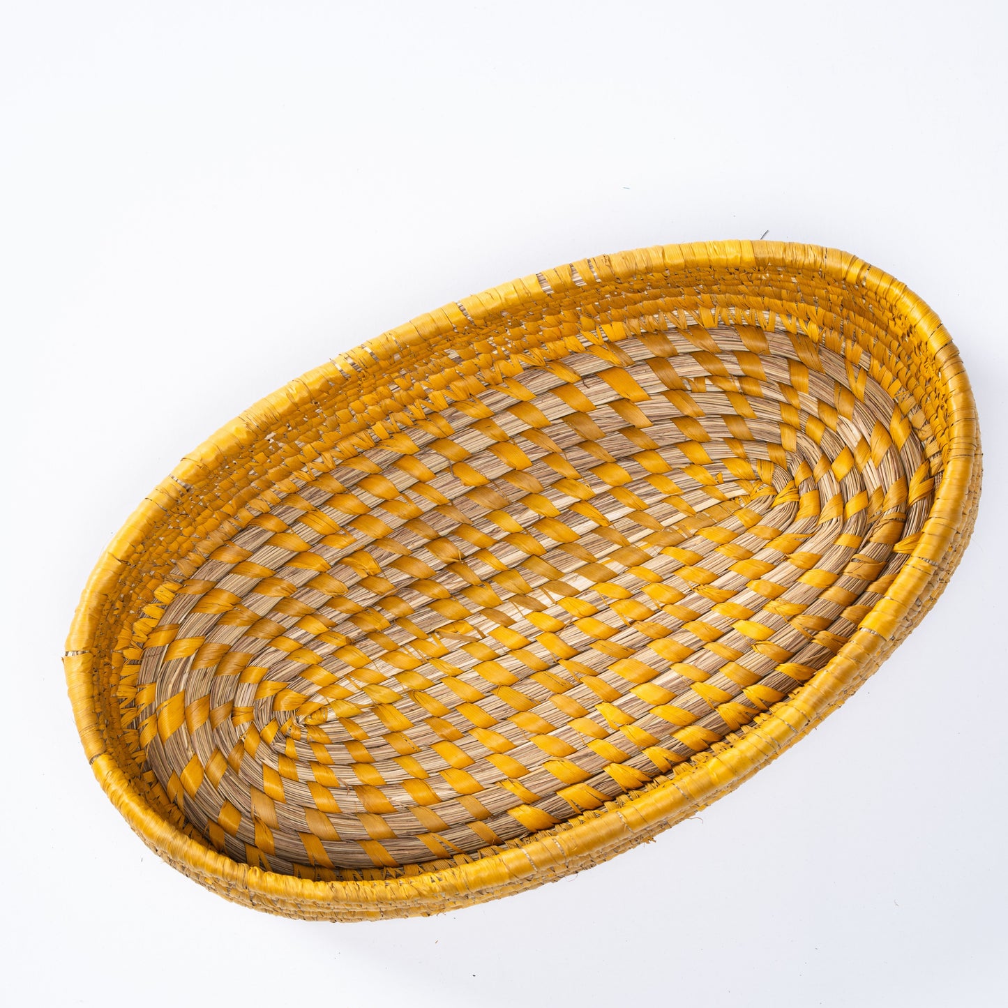 Top-down view of the yellow oval basket showcasing the detailed spiral weave and vibrant pattern.