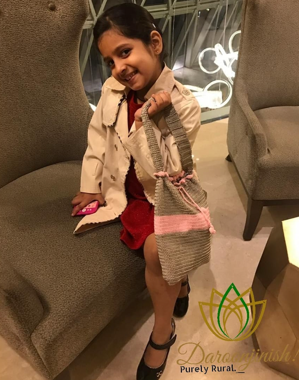 Young girl holding a handmade sabai grass bag