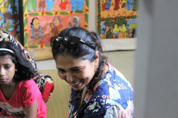 Woman smiling during a craft workshop with children