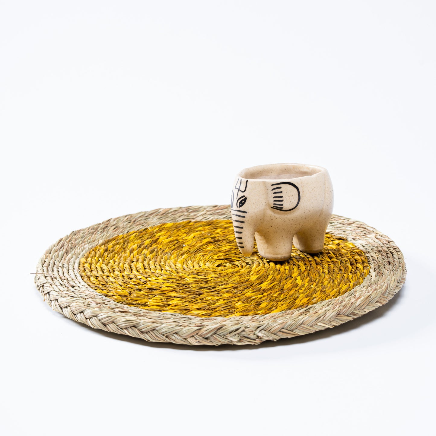 Artisan-crafted yellow Sabai mat on wooden surface

