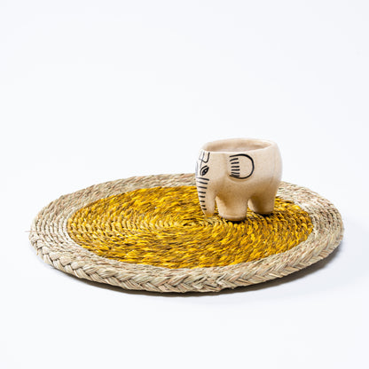 Artisan-crafted yellow Sabai mat on wooden surface

