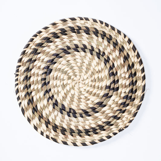Black and white handwoven Sabai grass plate mat top view