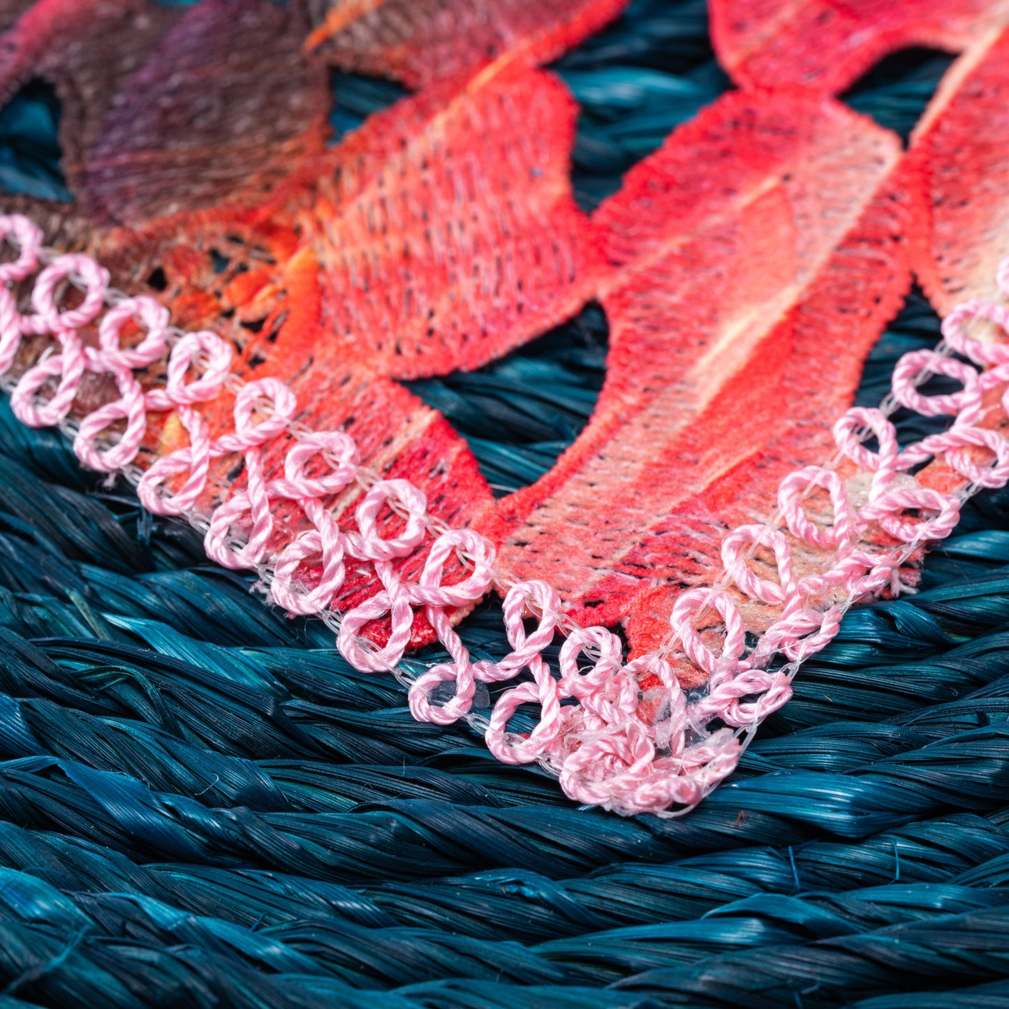 Macro view of pastel embroidered center on sabai weave

