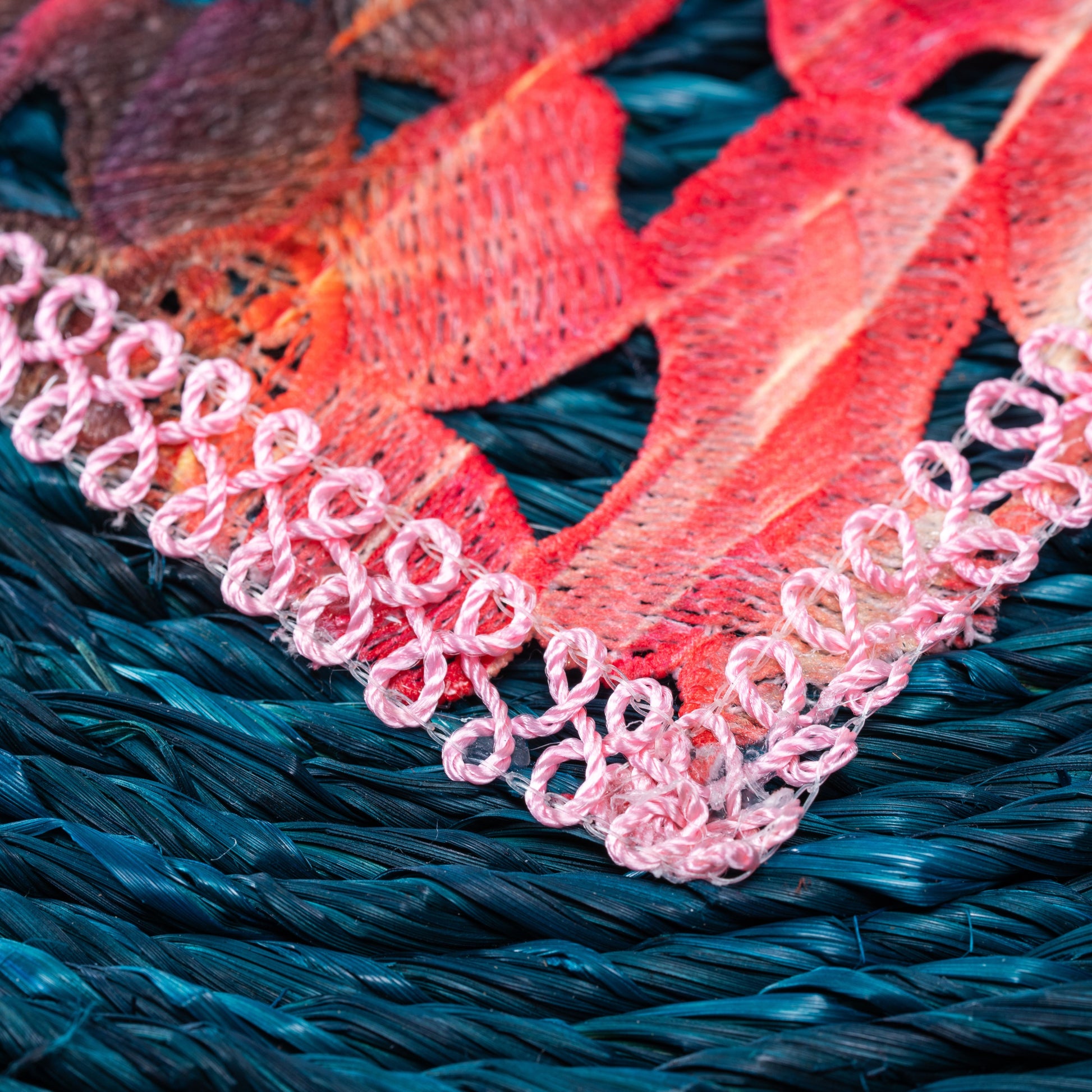 Macro view of pastel embroidered center on sabai weave

