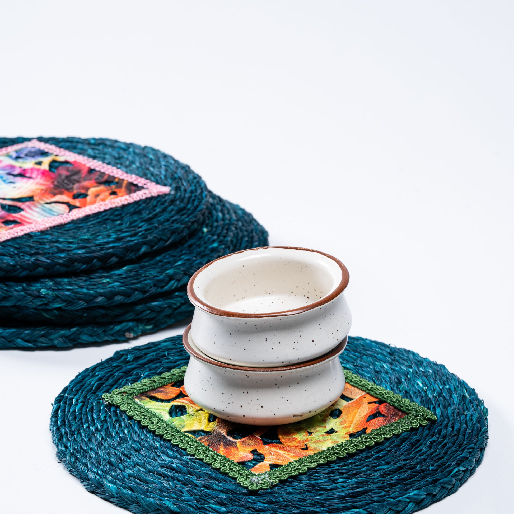 Stacked indigo sabai mats with cups to illustrate size and use

