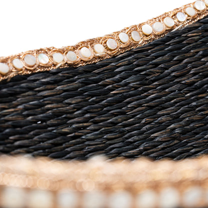 Close-up of the sabai basket's edge showing fine black weave and beaded trim