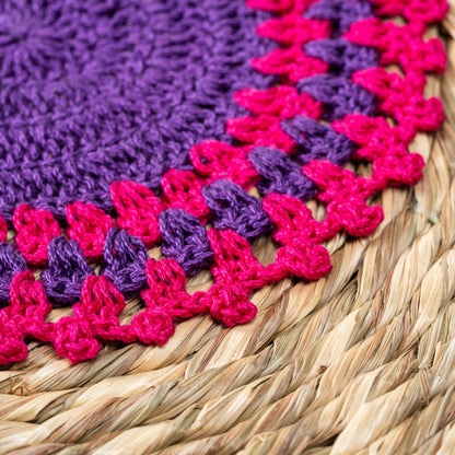Close-up of pink and purple crochet detailing on mat – macro shot

