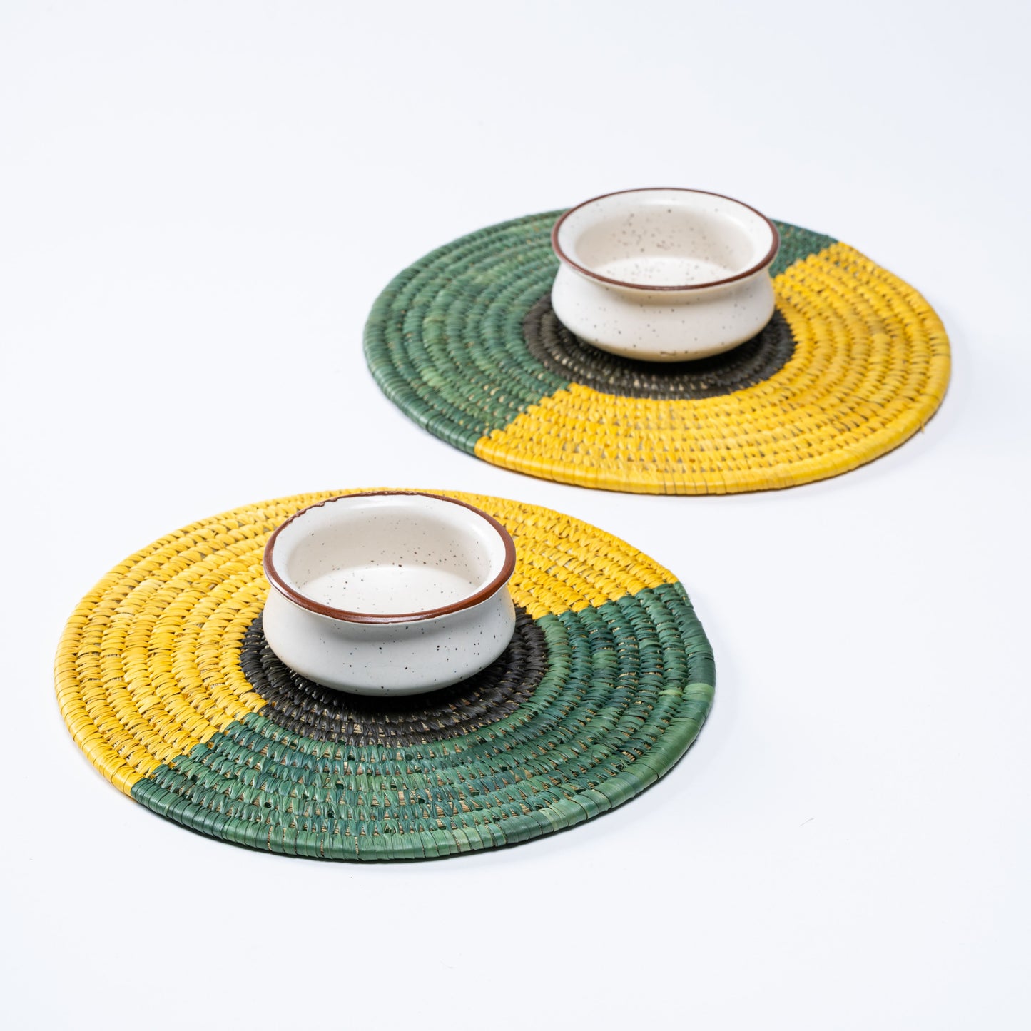 Pair of Tricolour Sabai Plate Mats styled with ceramic bowls for table setting.