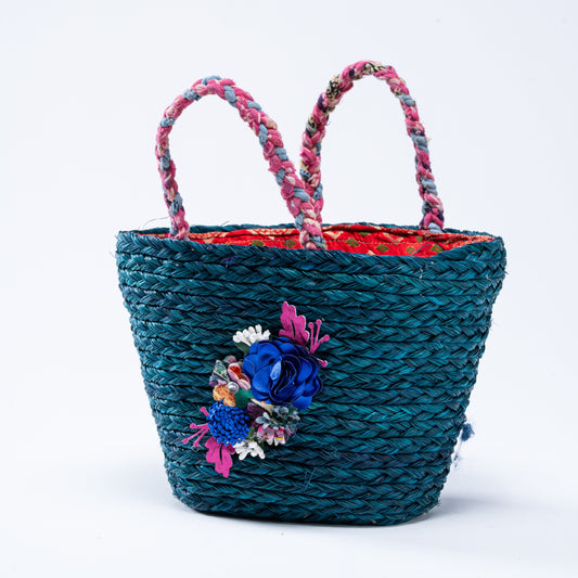 Front view of the Trina Sabai Mini Basket with blue woven body and floral embellishment


