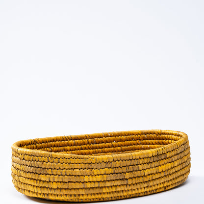 Full side view of the yellow oval basket on a white background, emphasizing its oval shape.
