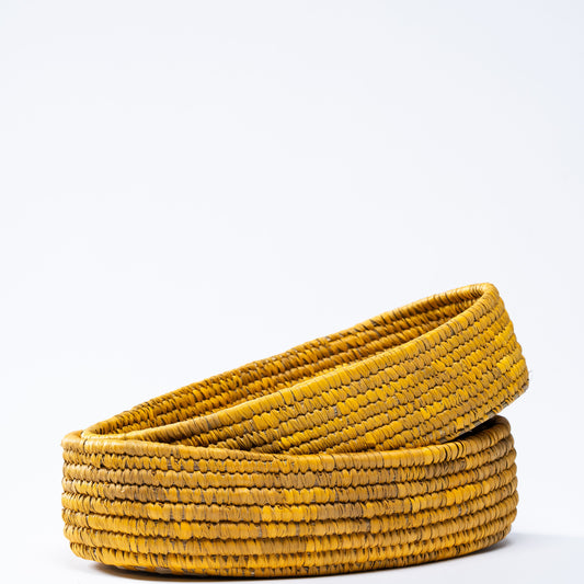 Two yellow oval baskets stacked together, showing their size and craftsmanship.