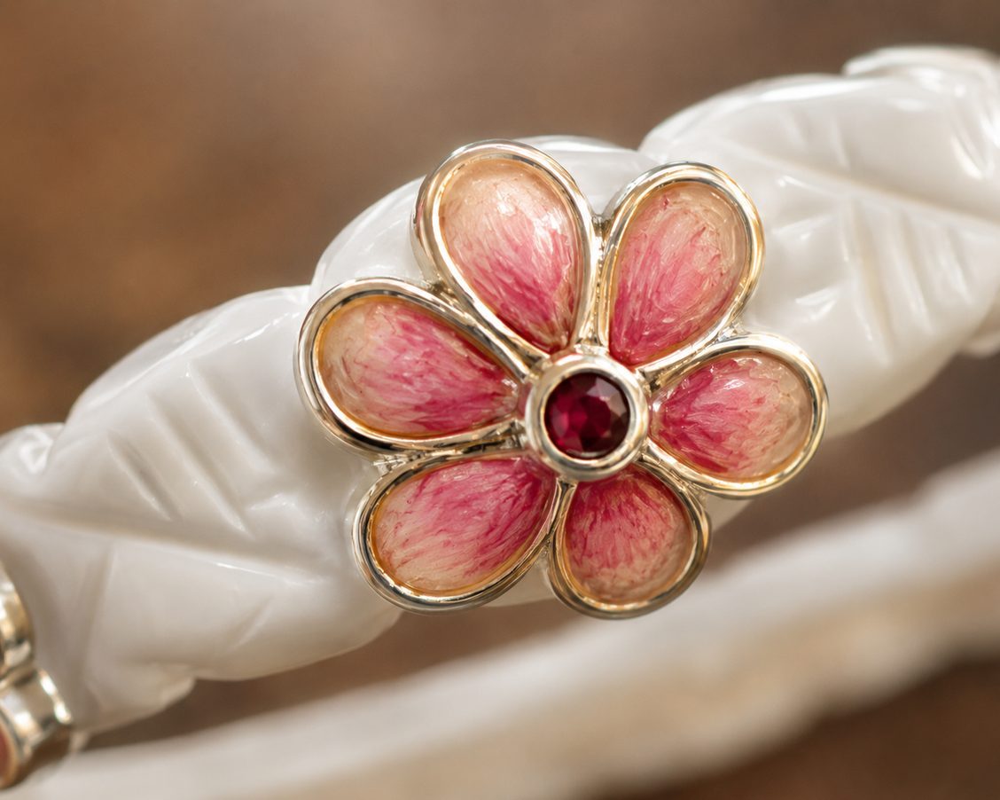 Close-up of a gulabi meenakari flower set on a white shakha